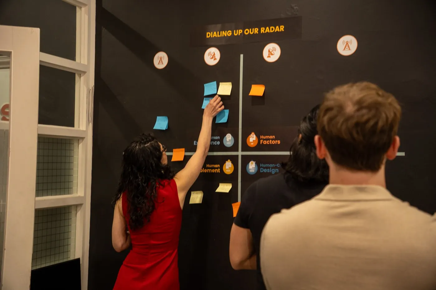 Workshop participants adding ideas to a wall during an Opposite session